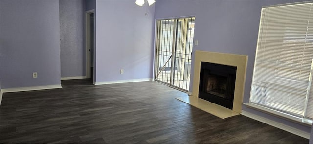 unfurnished living room featuring ceiling fan and dark hardwood / wood-style flooring