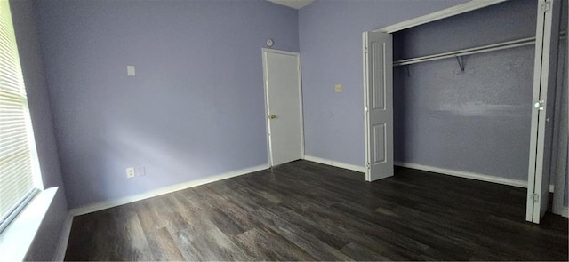 unfurnished bedroom with a closet and dark wood-type flooring