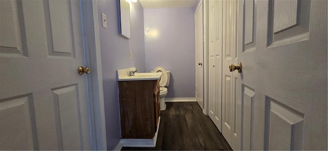 bathroom featuring vanity, hardwood / wood-style flooring, and toilet