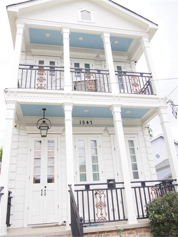 doorway to property with a balcony and a porch