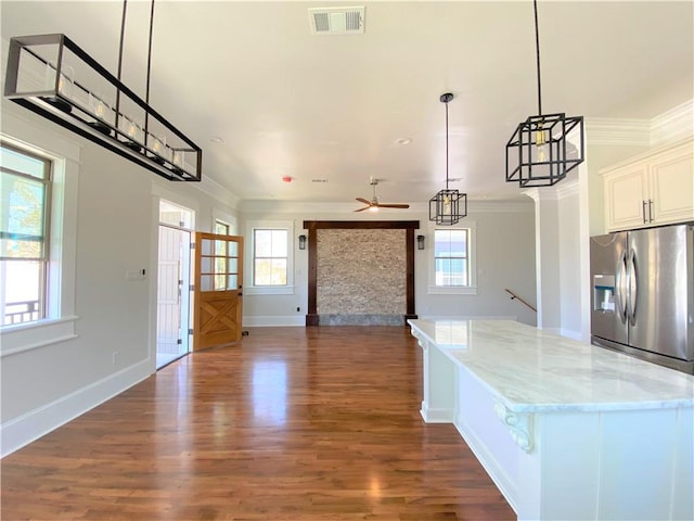 kitchen featuring ceiling fan, plenty of natural light, stainless steel fridge with ice dispenser, and white cabinetry