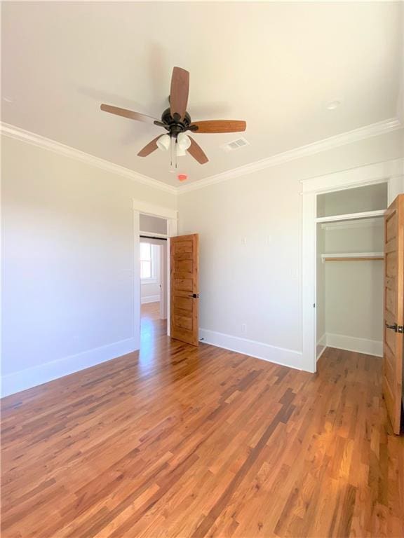 unfurnished bedroom with ceiling fan, a closet, light wood-type flooring, and ornamental molding