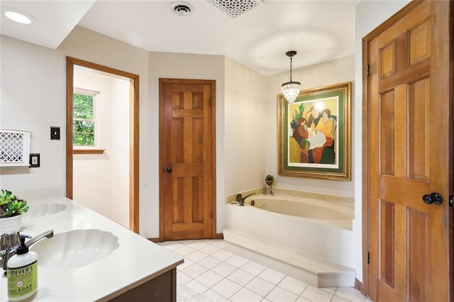 bathroom with tile patterned floors, a bathing tub, vanity, and an inviting chandelier