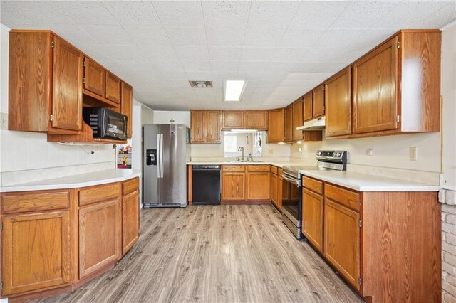 kitchen featuring black appliances, sink, and light hardwood / wood-style floors