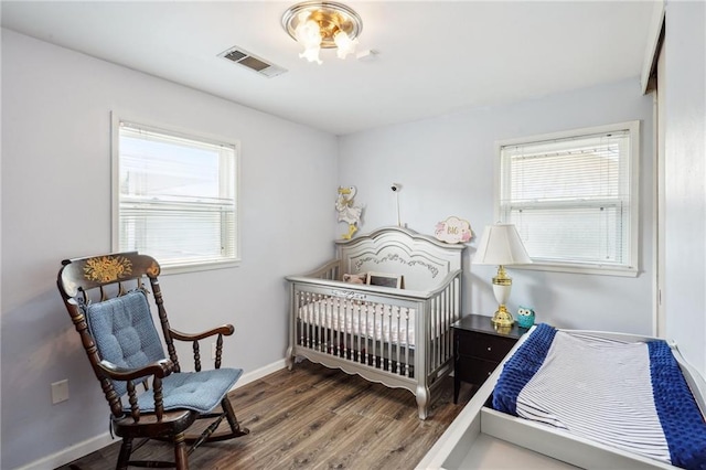 bedroom with a crib and hardwood / wood-style floors