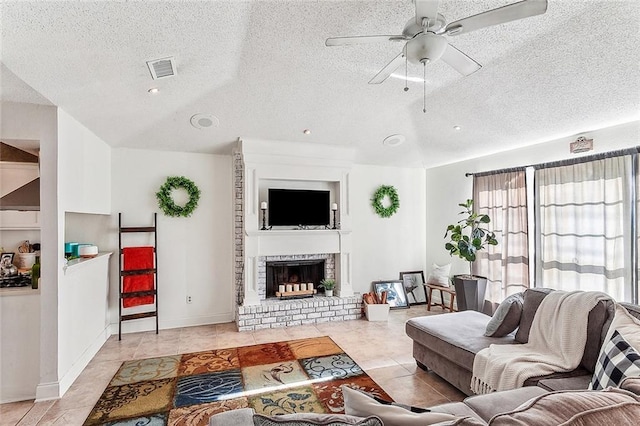 living room with ceiling fan, a fireplace, light tile patterned floors, and vaulted ceiling