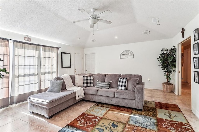 tiled living room with ceiling fan, a raised ceiling, and a textured ceiling