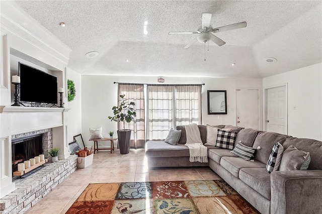 tiled living room with lofted ceiling, ceiling fan, a fireplace, and a textured ceiling