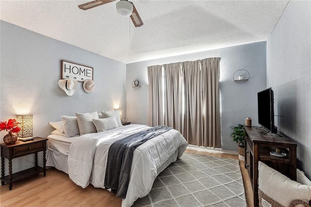 bedroom featuring a textured ceiling, light hardwood / wood-style floors, and ceiling fan