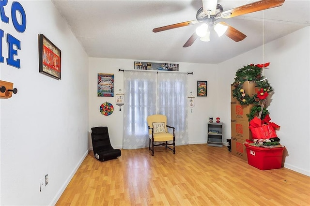 living area featuring hardwood / wood-style floors and ceiling fan