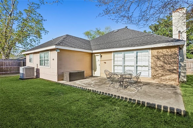 back of property with a yard, a patio area, and central air condition unit