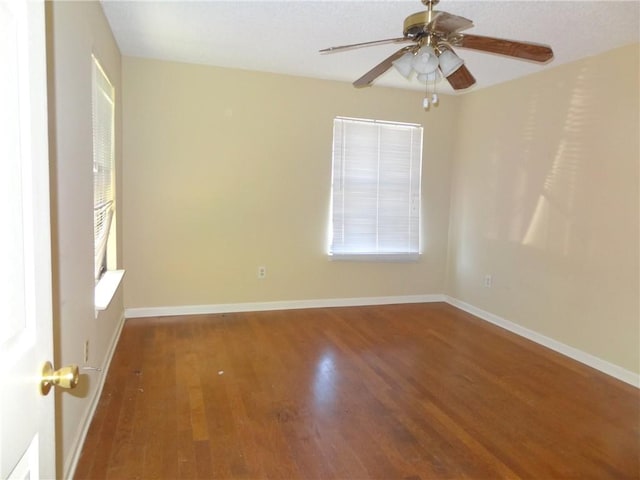 spare room featuring ceiling fan, plenty of natural light, and dark hardwood / wood-style floors