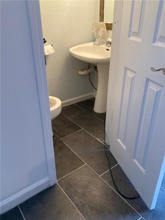 bathroom featuring sink, tile patterned flooring, and toilet