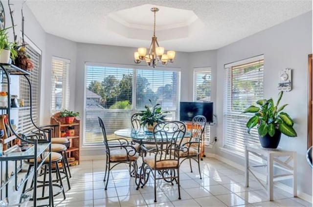 tiled dining room with a tray ceiling, a notable chandelier, a textured ceiling, and a healthy amount of sunlight