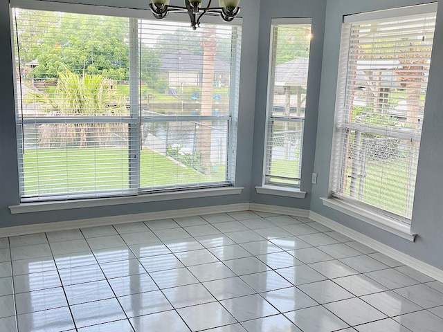 unfurnished dining area featuring plenty of natural light, an inviting chandelier, and light tile patterned floors