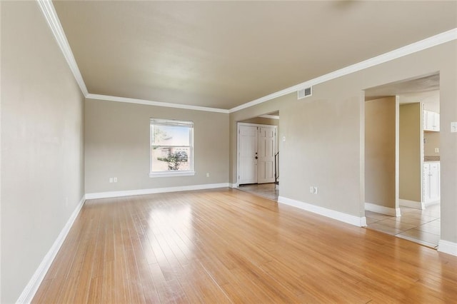 spare room with light hardwood / wood-style floors and crown molding