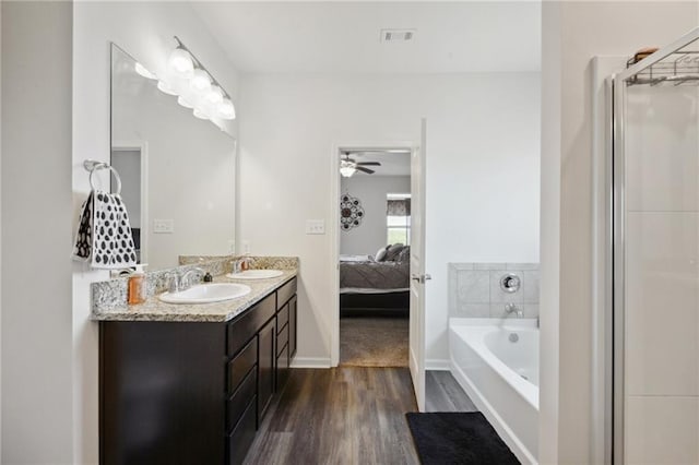 bathroom with hardwood / wood-style flooring, vanity, and a bathtub