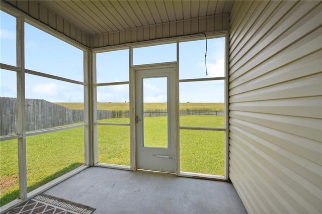 unfurnished sunroom with a wealth of natural light and a rural view