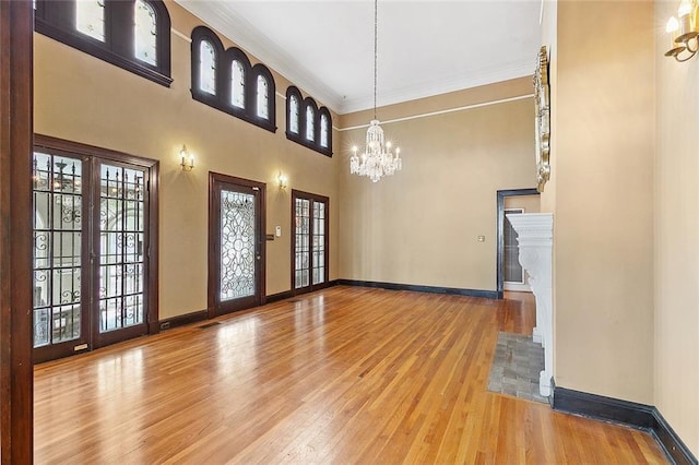 interior space featuring ornamental molding, french doors, a chandelier, and hardwood / wood-style flooring