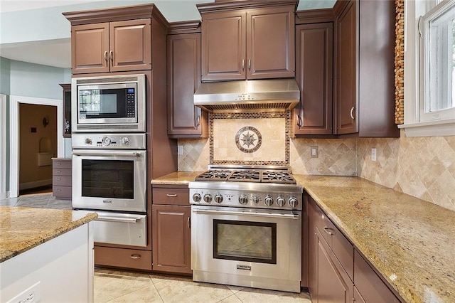 kitchen featuring light stone countertops, appliances with stainless steel finishes, tasteful backsplash, and light tile patterned flooring