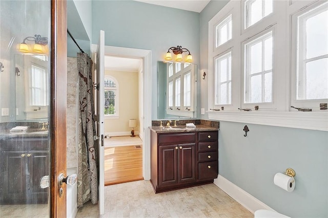 bathroom with a shower with shower curtain, wood-type flooring, vanity, and ornamental molding