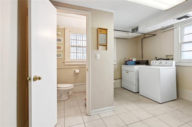 laundry room with washing machine and clothes dryer and light tile patterned floors