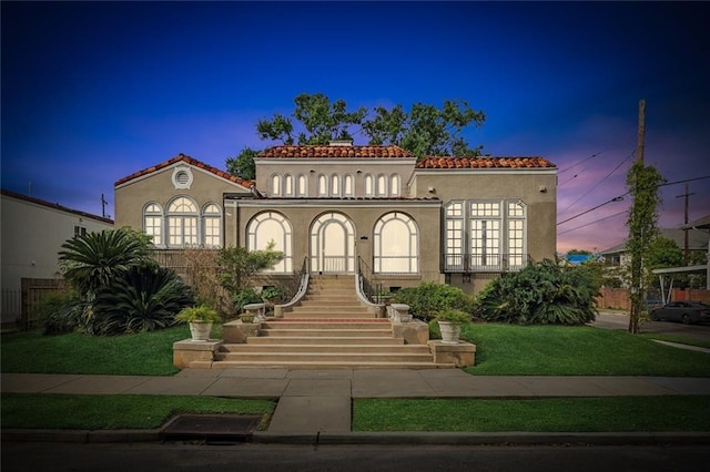 mediterranean / spanish house featuring a lawn