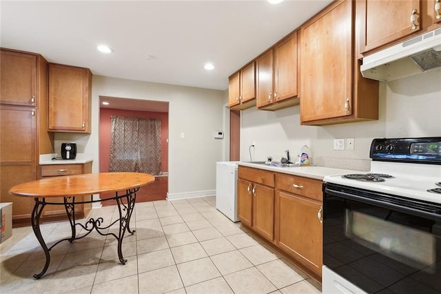 kitchen featuring under cabinet range hood, a sink, electric stove, light countertops, and brown cabinetry