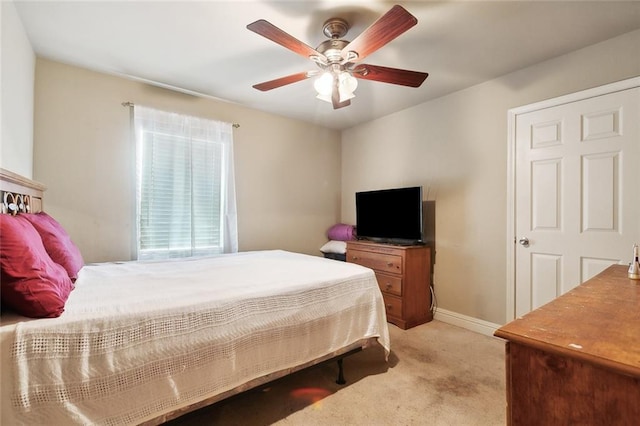 bedroom with light carpet, ceiling fan, and baseboards