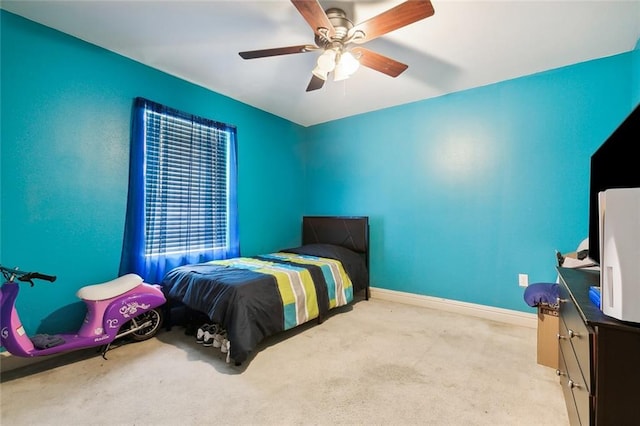 bedroom with light carpet, ceiling fan, and baseboards