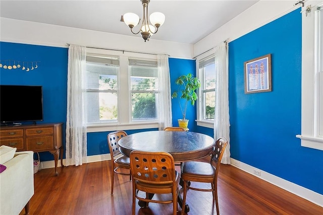 dining room with an inviting chandelier and dark wood-type flooring