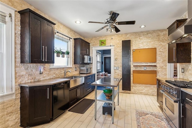 kitchen with wall chimney exhaust hood, a center island, stainless steel appliances, dark brown cabinets, and sink