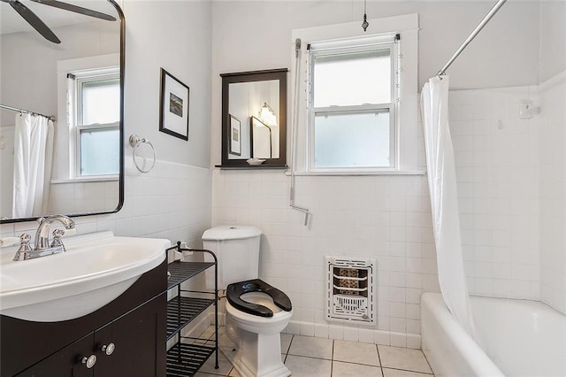 full bathroom featuring tile walls, ceiling fan, toilet, tile patterned floors, and heating unit