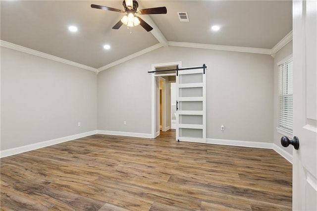 unfurnished bedroom with crown molding, hardwood / wood-style flooring, ceiling fan, vaulted ceiling with beams, and a barn door