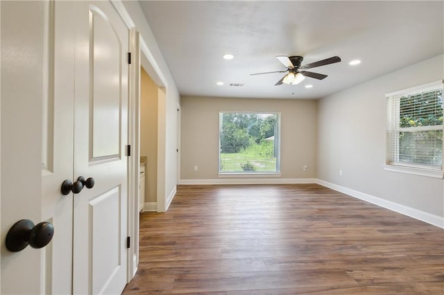 spare room with dark hardwood / wood-style flooring and ceiling fan