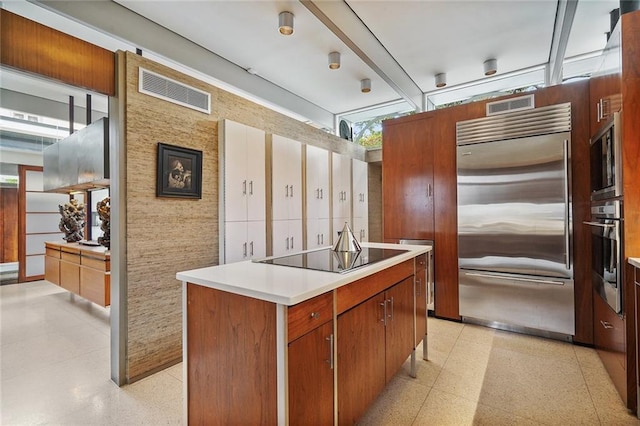 kitchen with built in appliances and a kitchen island