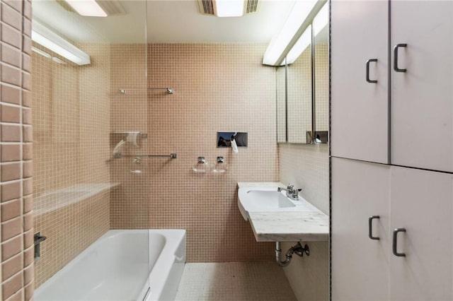 bathroom featuring tile walls and sink