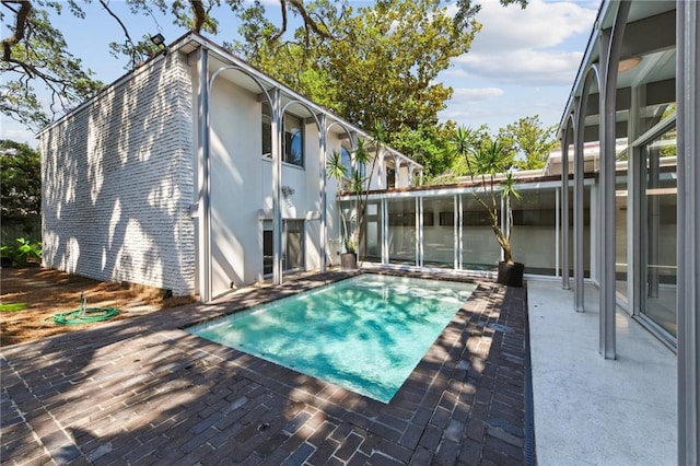 view of pool featuring a patio area and a sunroom