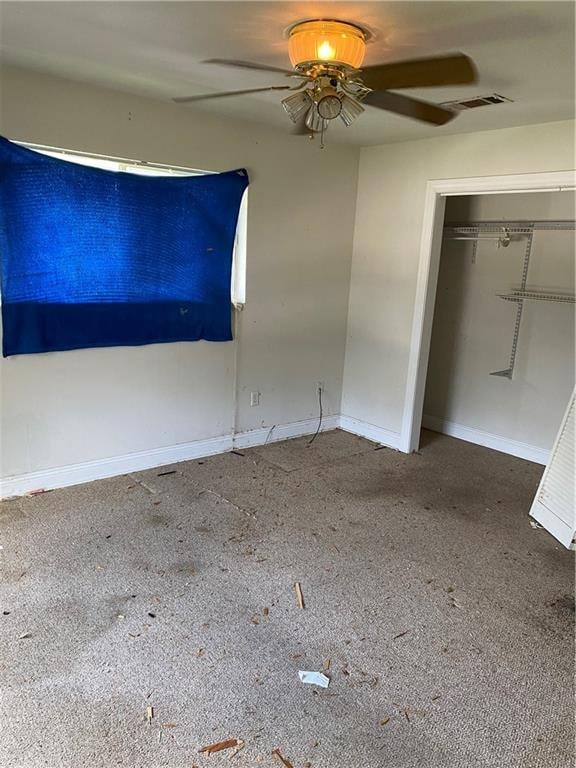 unfurnished bedroom with ceiling fan and a closet