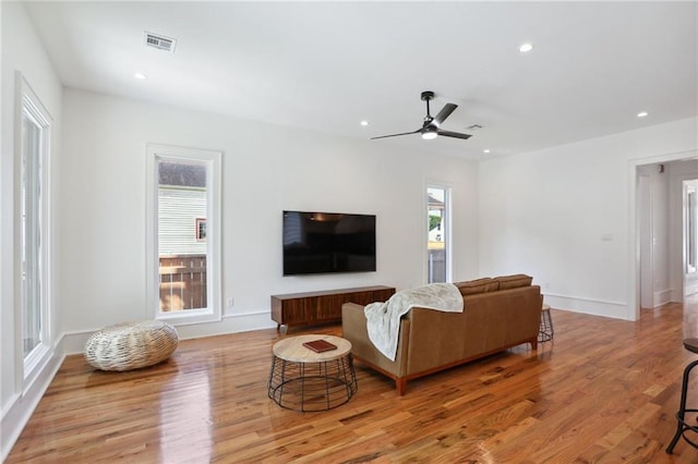 living room featuring ceiling fan and light hardwood / wood-style floors