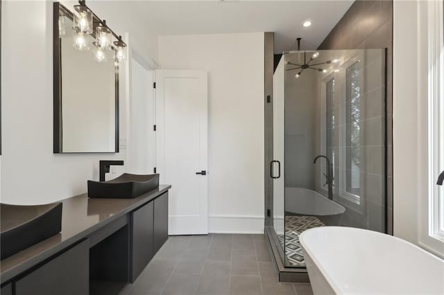 bathroom featuring tile patterned flooring, vanity, shower with separate bathtub, and an inviting chandelier