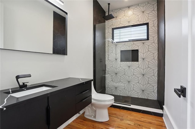 bathroom featuring toilet, hardwood / wood-style floors, vanity, and walk in shower