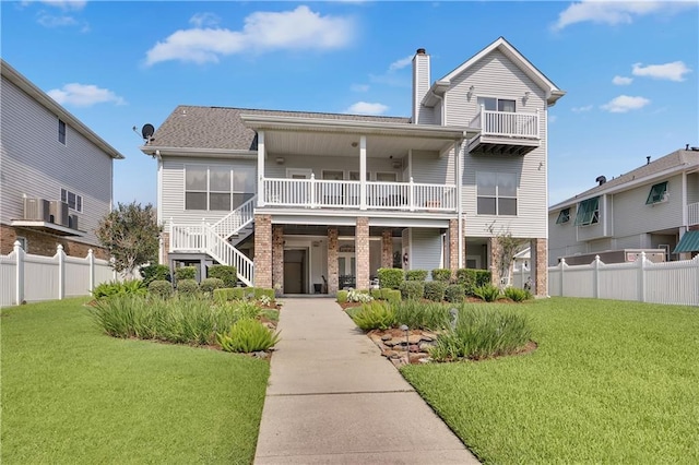 view of front facade featuring a balcony and a front lawn