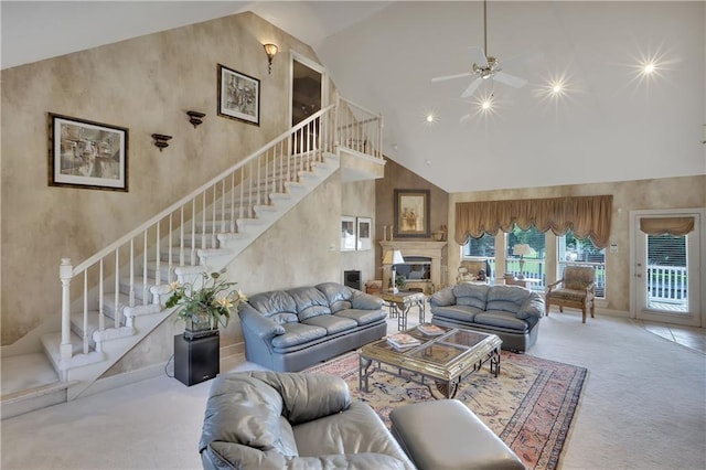 carpeted living room with ceiling fan and high vaulted ceiling