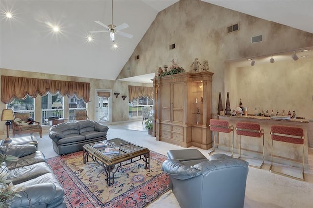 carpeted living room with ceiling fan and high vaulted ceiling