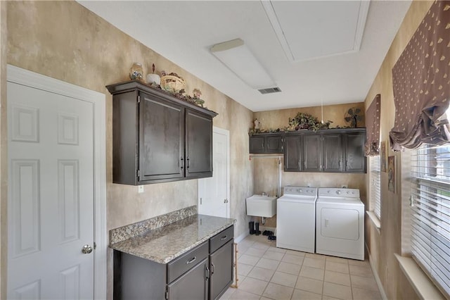 washroom featuring cabinets, washing machine and dryer, sink, and light tile patterned floors