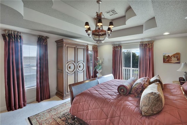 carpeted bedroom with crown molding, a chandelier, a textured ceiling, and a tray ceiling