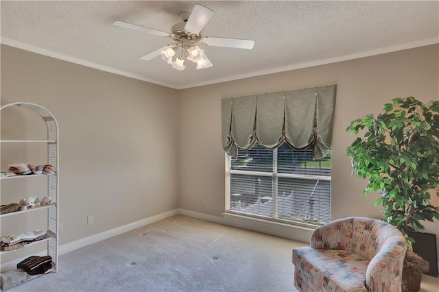 living area with ceiling fan, ornamental molding, light carpet, and a textured ceiling