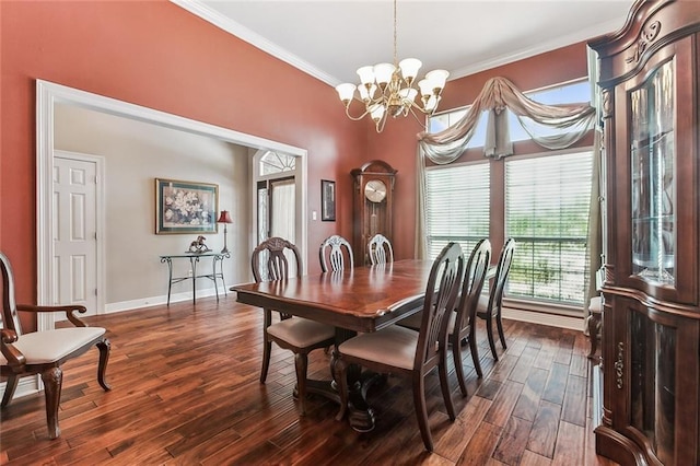 dining area with dark wood-type flooring, crown molding, and a notable chandelier