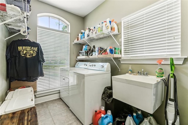 clothes washing area featuring sink, washer and dryer, and light tile patterned floors